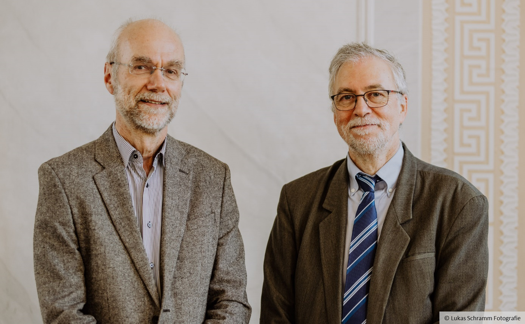 Two men smiling at the camera.